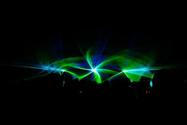 Grüne und blaue Laser erzeugen eine abstrakte Lichtformation bei einer Show von LLS