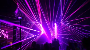 Pinkes Lasernetz über dem Publikum bei einer Lasershow der Firma LLS