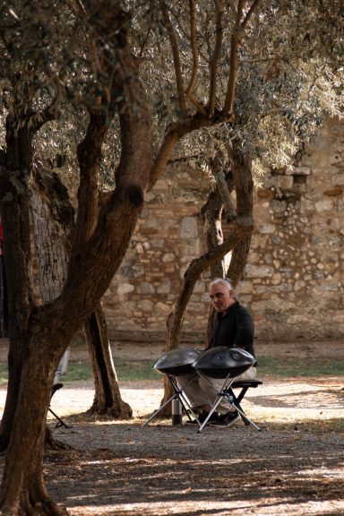 Alter Olivenbaum und Musiker in San Gimignano inmitten der toskanischen Landschaft
