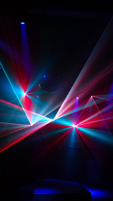 Mehrfarbige Laserstrahlen in Rot, Blau und Türkis bei einer Show von LLS