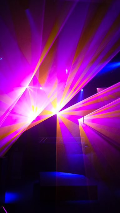 Farbenfrohe Lasershow von LLS mit pinken, gelben und blauen Laserstrahlen