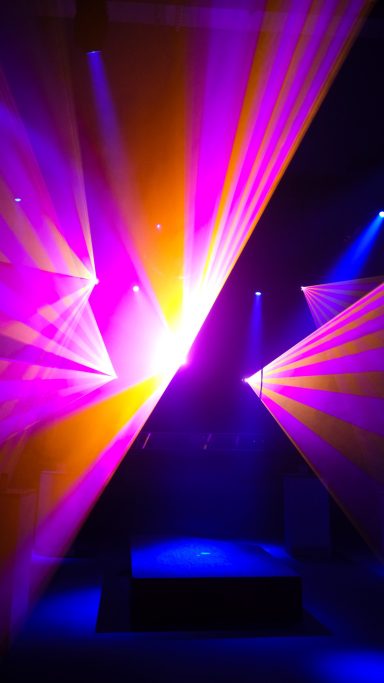 Intensive pinke und gelbe Laserstrahlen bei einer Lasershow der Firma LLS