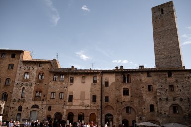 Historischer Platz mit Steinhäusern und Turm in San Gimignano, Italien