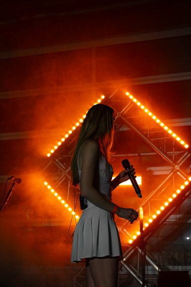 Sängerin der Partyband Sauwuid im Bühnenlicht während eines Live-Auftritts beim Pucher Hallenfetz in Fürstenfeldbruck