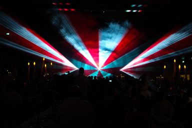 Rot-weiße Laserstrahlen über dem Publikum bei einer Lasershow von LLS