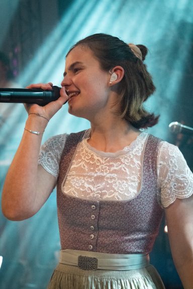 Sängerin Kleo der Partyband Sauwuid im Dirndl während eines Live-Auftritts
