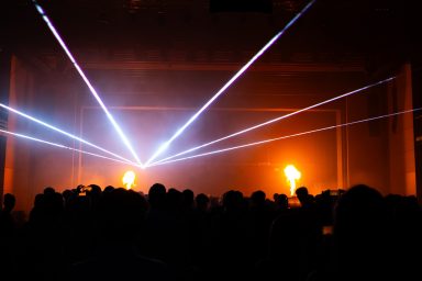 Lasershow von LLS mit Flammenwerfern über den Silhouetten des Publikums bei einer Veranstaltung