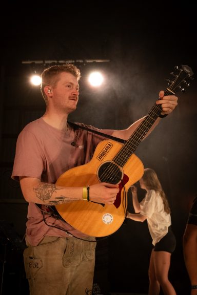 Gitarrist der Partyband Sauwuid mit Akustikgitarre bei einem Live-Auftritt