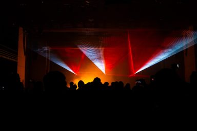 Weiße und mehrfarbige Laserstrahlen mit Flammenwerfern bei einer Lasershow der Firma LLS