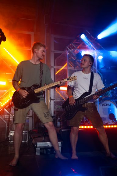 Zwei Gitarristen der Partyband Sauwuid gemeinsam auf der Bühne beim Pucher Hallenfetz