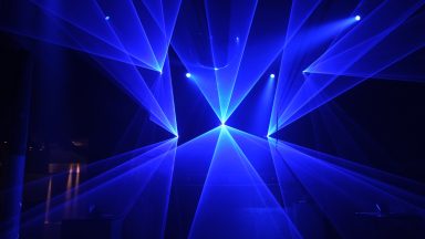 Blaue Laserstrahlen und geometrische Lichtformen bei einer Lasershow von LLS
